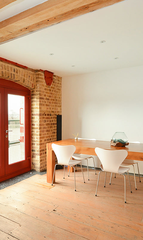 interior of london warehouse conversion with timber beams and loading bay doors