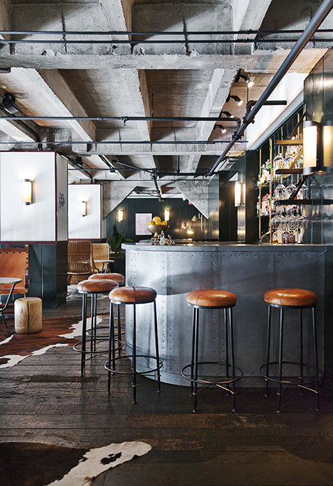 luxe industrial restaurant interior with raw concrete ceiling