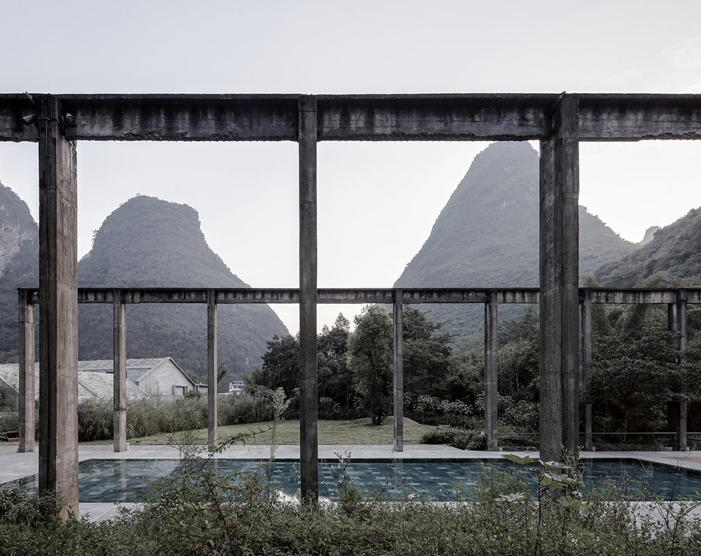 concrete pylons frame an outdoor pool at alila yangshuo, a converted sugar factory cum hotel in china photography by Shengliang  Su