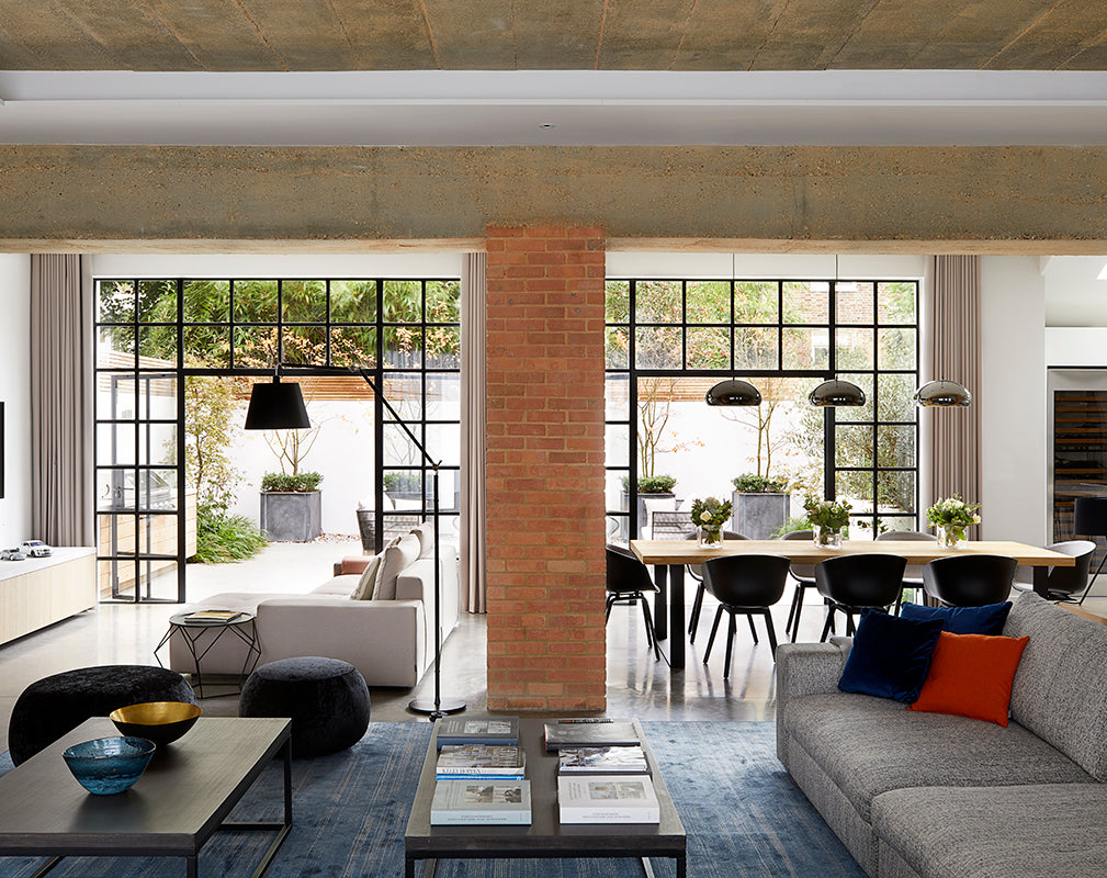 a raw concrete ceiling and original brick column were left exposed in this industrial conversion