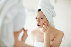 detox woman looking at acne in mirror