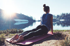 Woman laying down on mat doing yoga on vacation