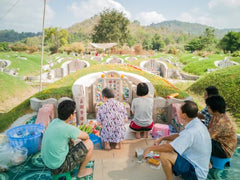 People celebrating Qing Ming Jie Day sit around a tomb