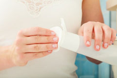 woman putting tea toner on cotton ball