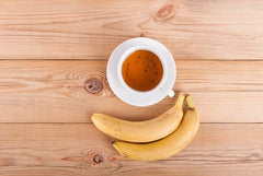 Banana and tea sitting on wooden table