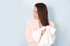 woman drying her long hair with a towel after a tea rinse