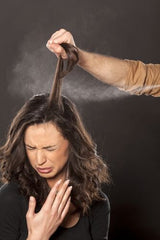 Woman coughing as her hair is sprayed with hairspray