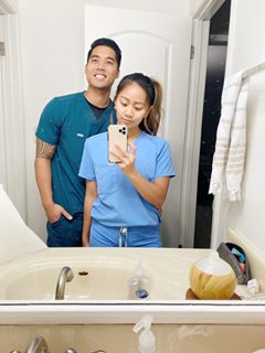 Nurses in scrubs posing for picture in bathroom