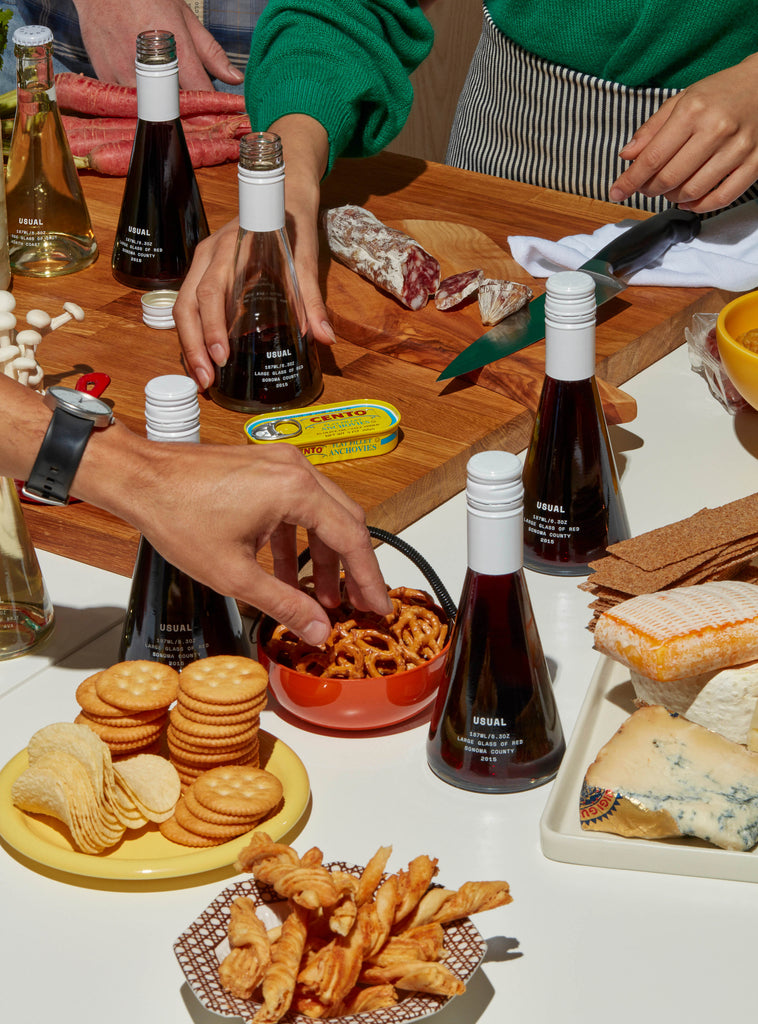 An outdoor wine tasting party with plates of appetizers