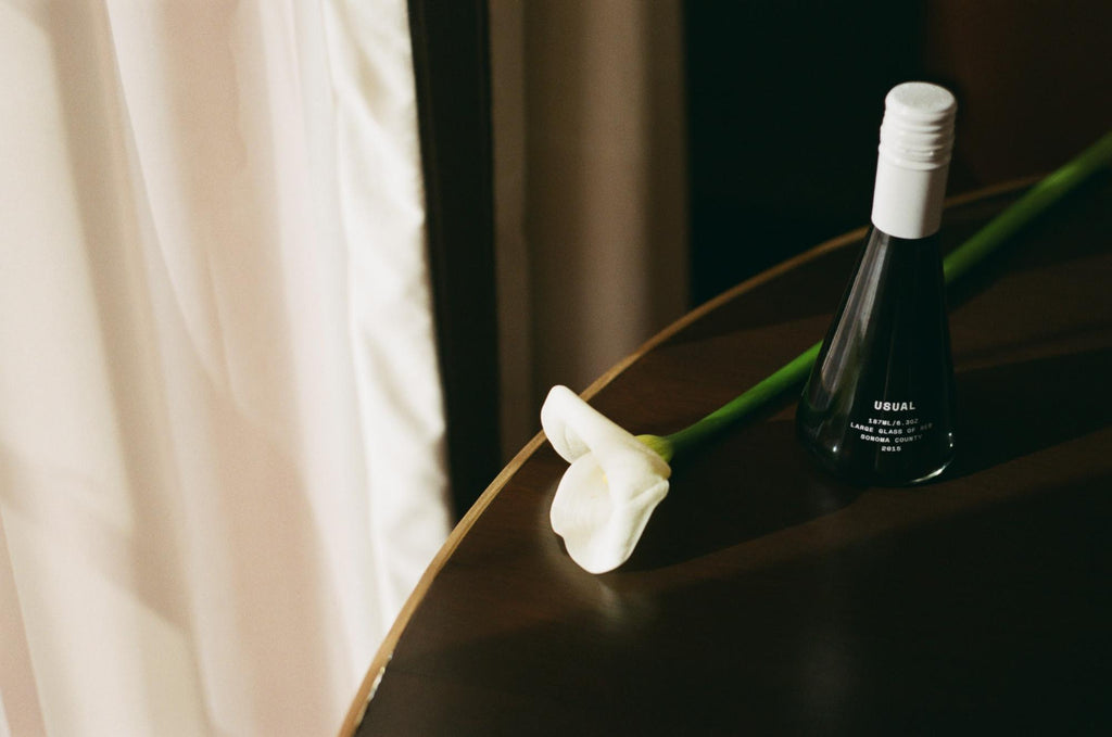 wine beside beautiful white flower under the table