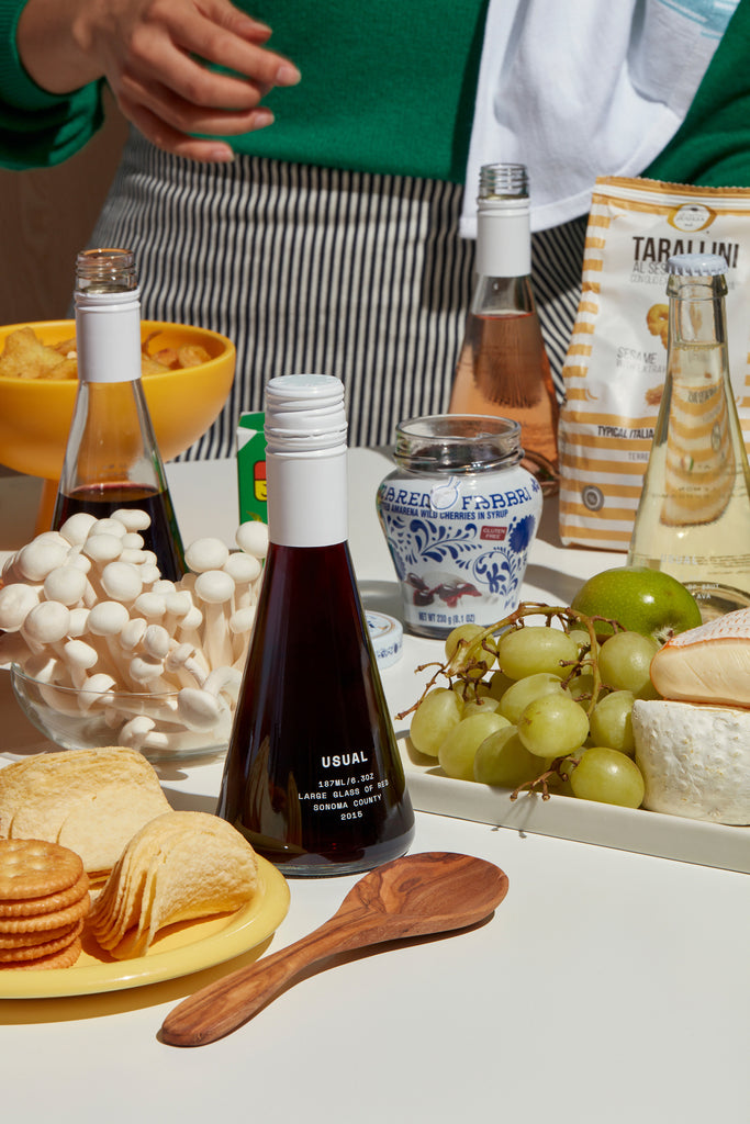A table spread with wine and cheese and other snacks