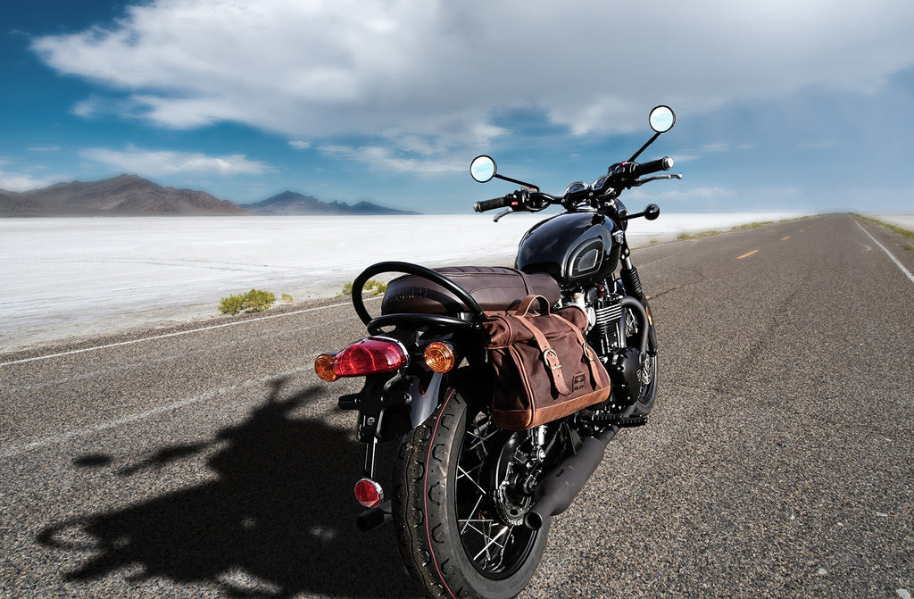 Bonneville T120 black with a brown saddlebag in the desert.