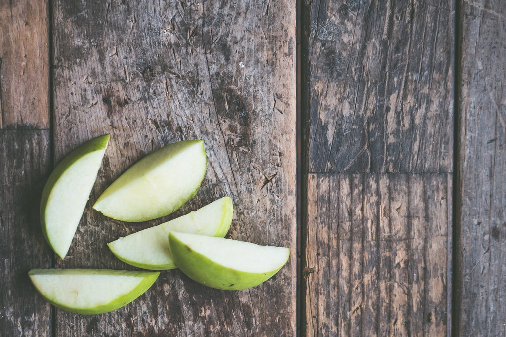 Cut green apples on wooden table helping keep menopause at bay