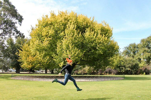 women leaping through a park