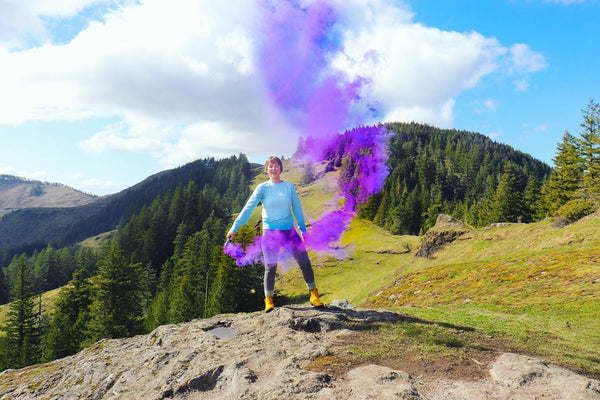 women on a mountain top colour bombing purple