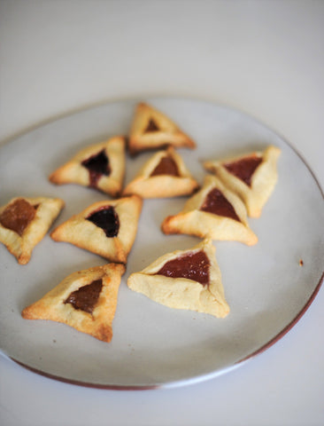 Jam-filled Hamantaschen on a plate by Issa Pottery