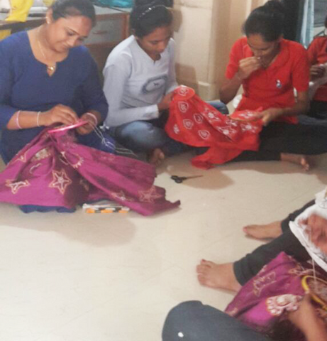 Women hand embroidering Christmas decorations in India