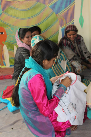 A group of women embroidering cloth