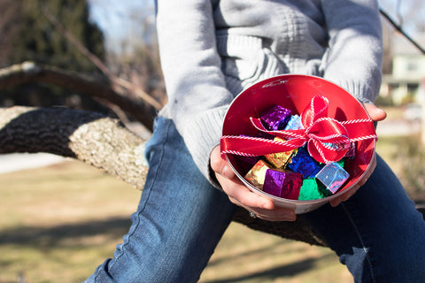 Vibrant red hand blown glass bowl filled with chocolates for a beautiful valentine's day gift.