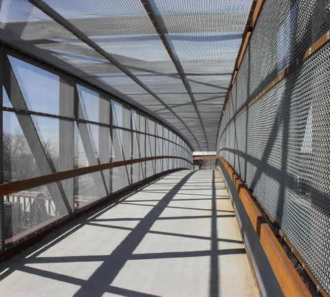 A walk bridge enclosed in commercial chain link fabric