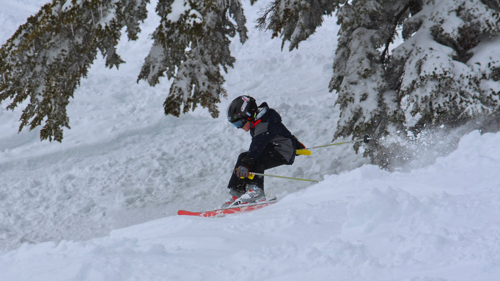 Young skier shredding downhill