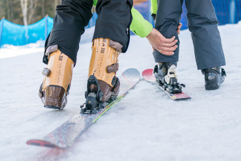 Parent helping child into ski boots