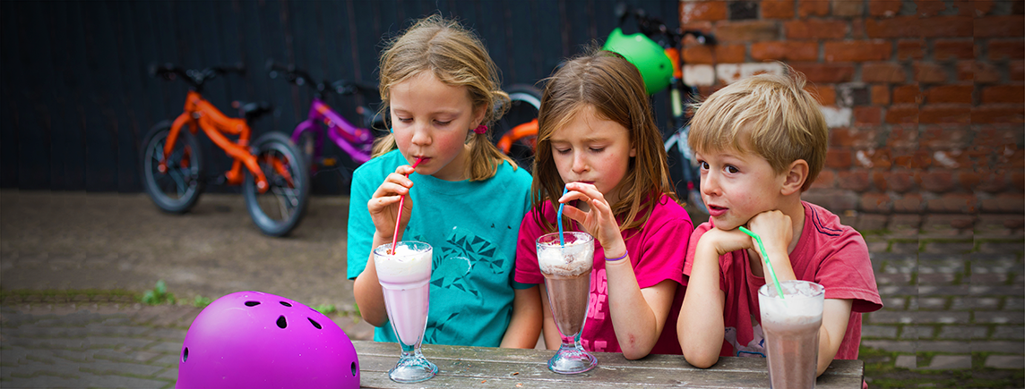 Kids drinking milkshake after bike ride