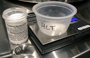 Measuring out potassium metabisulfite using a jewelry scale with 0.01 gram resolution