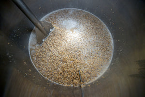Gently mixing the grain and salts with the mash paddle