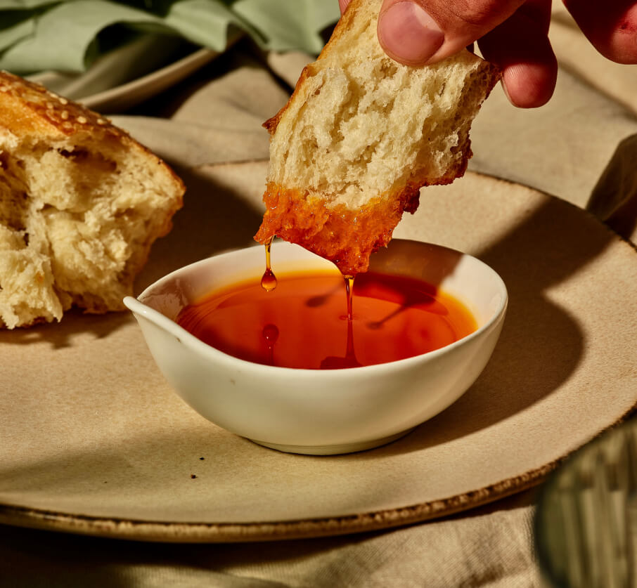 Bread dipping in red sauce