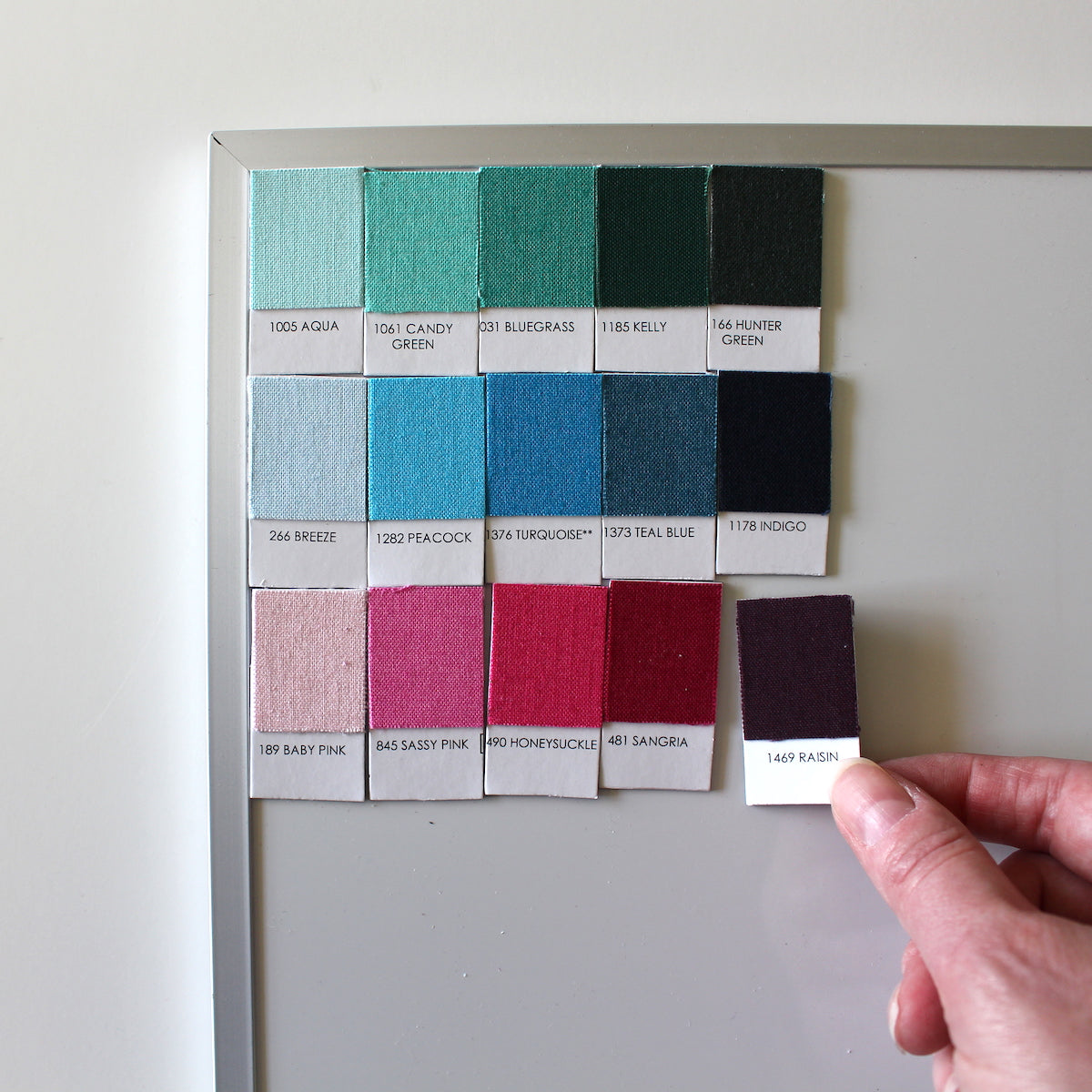placing Kona Cotton fabric swatch magnets on a whiteboard