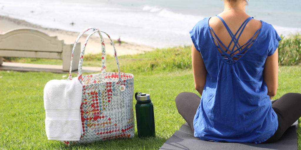 Meditating at beach with bag