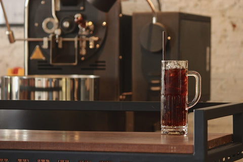 iced coffee in front of coffee roaster