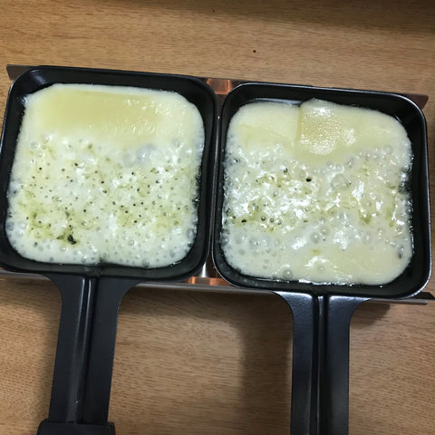 Melted Raclette Cheese in dishes of the Alpine Raclette Melter
