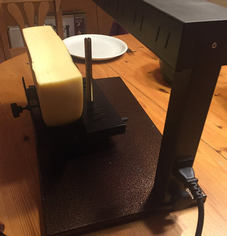 Raclette Cheese in cheese holder of the raclette melter
