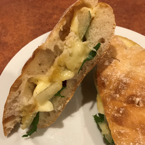 Breakfast sandwich with raclette cheese and pears on ciabatta bread