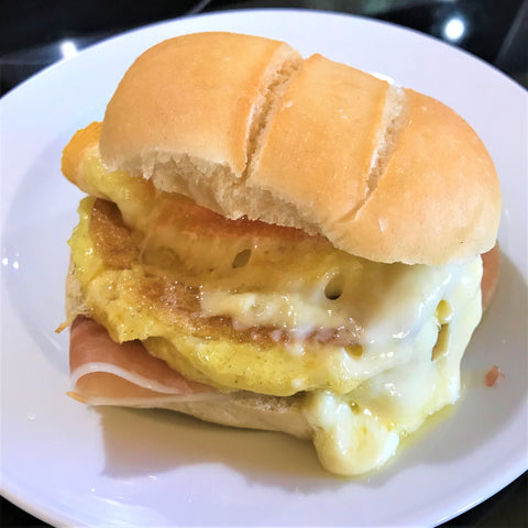 Raclette breakfast with egg, prosciutto and melted cheese