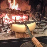 Raclette holder placed to the fire, waiting for the cheese to melt