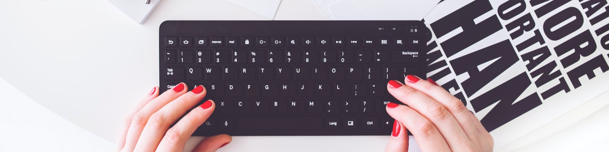 Womans hands writing on black keyboard