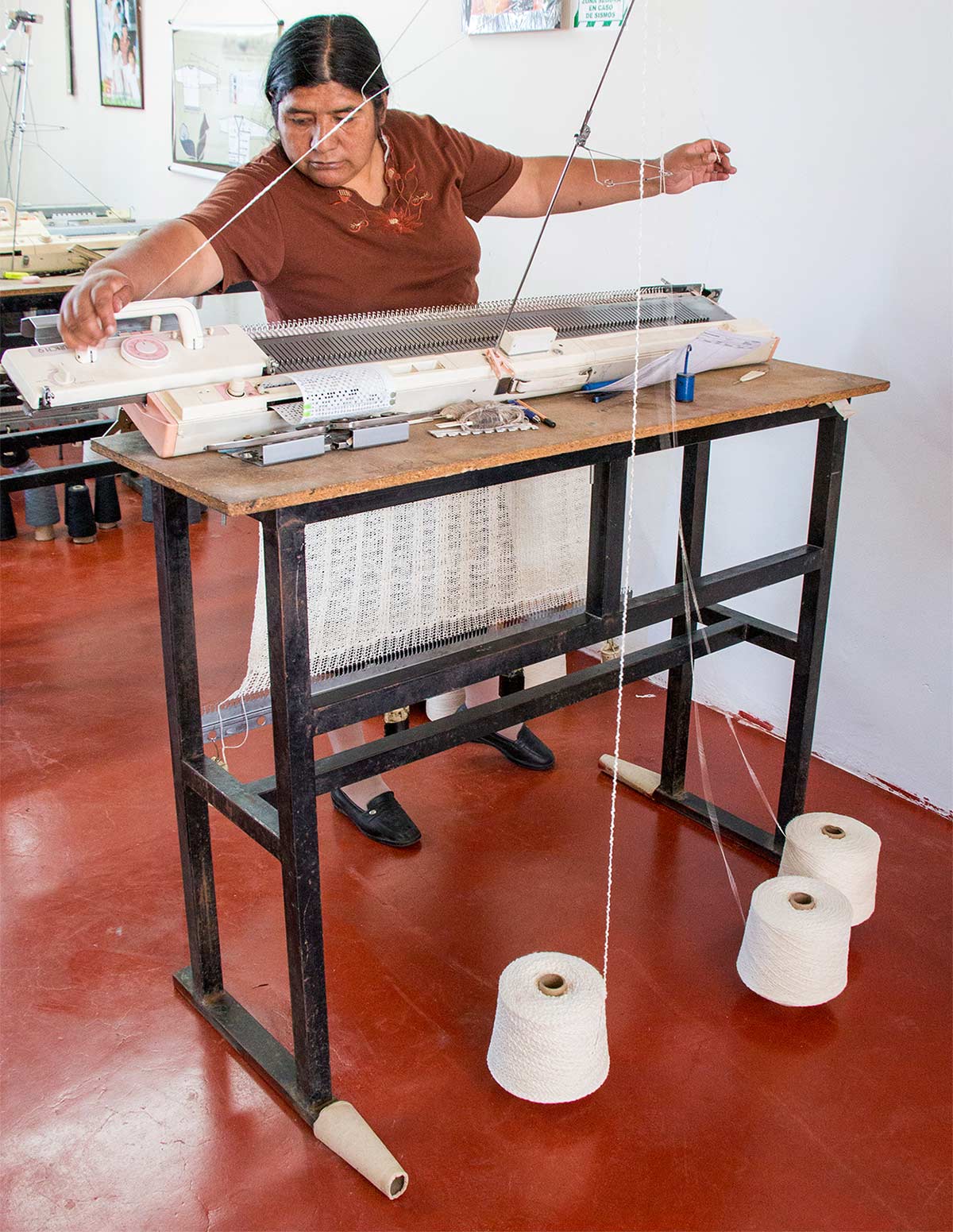 Artisan creating complicated knits on handknitting machine for our sustainable fashion line.