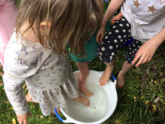 A group of children enjoy water play - Snail Mail Stories inspires children to play and learn in nature