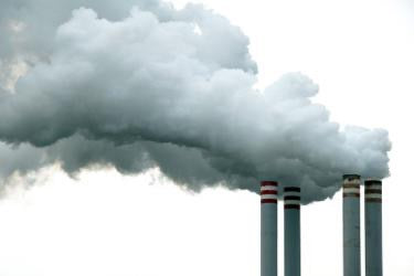 A picture containing industrial smokestacks, industrial chimneys, air pollution, steam, emission, white smoke