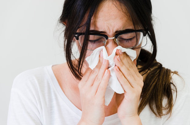 Woman blowing her nose.