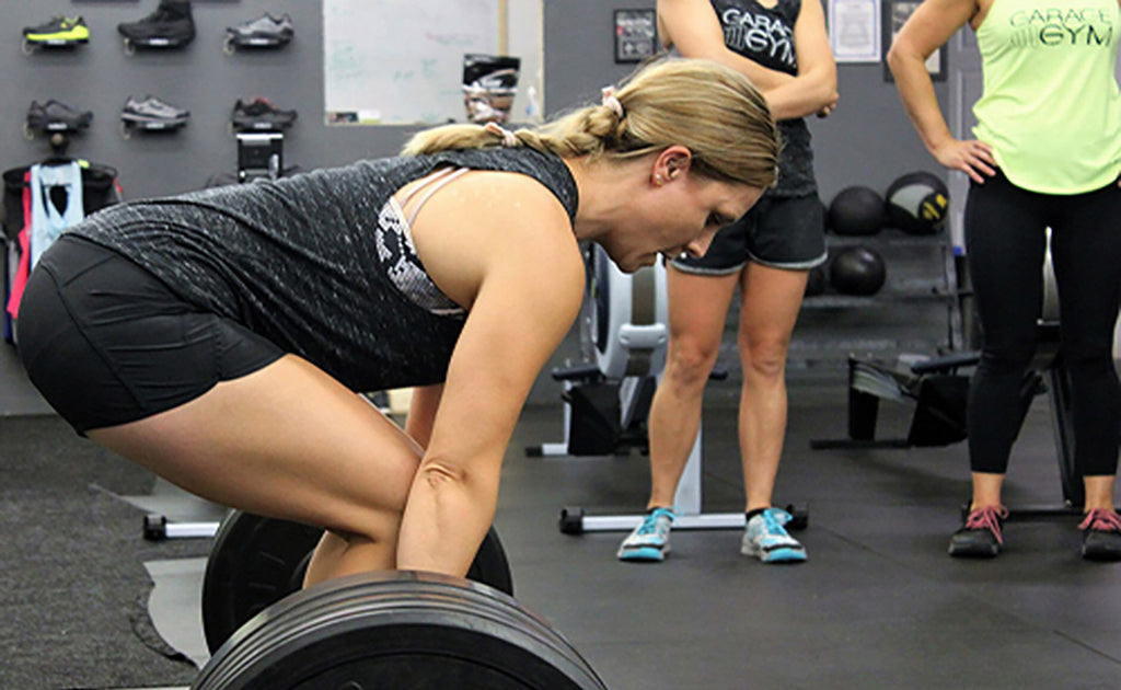 Woman deadlifting weight in gym