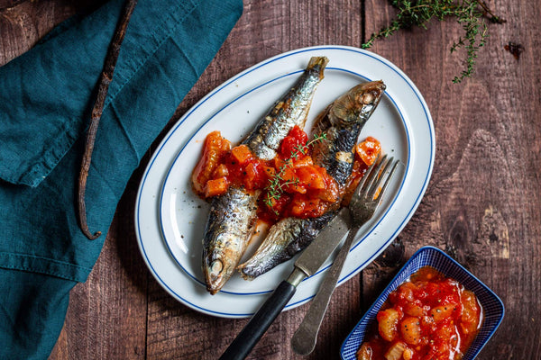 two poached sardines in a savory tomato and vanilla bean sauce