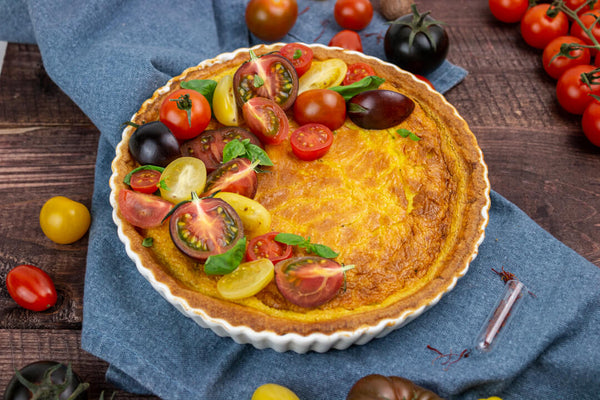 Tomato saffron quiche on a cloth napkin with basil garnish