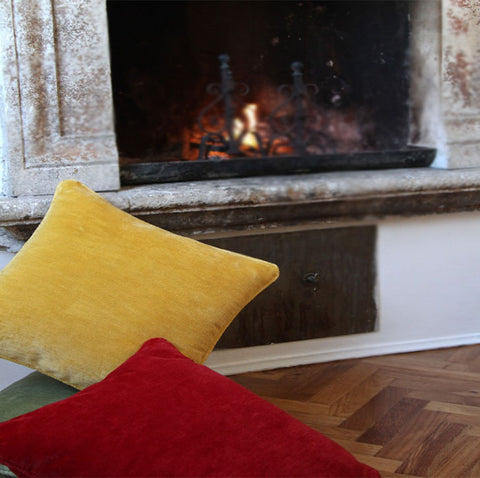 yellow pillow by floor of a fire