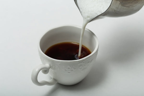 pouring milk over tea