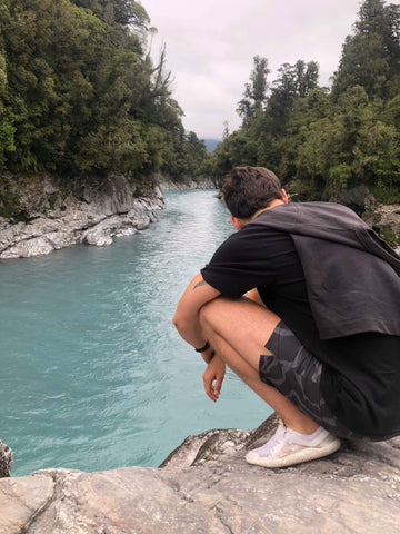 Liam demonstrating a benefit of good feet health - squatting (even better with a view) New Zealand.