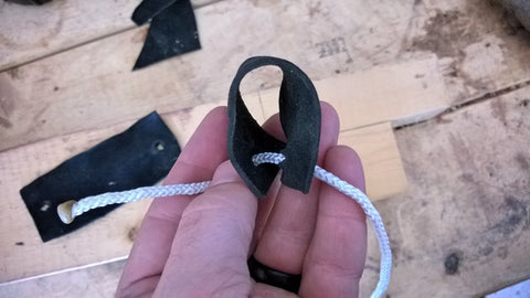 Create a loop with the leather strip by pulling the ends together.
